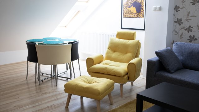 Győri órákra bérelhető lakás nappalijának részlete, fotellel és étkezősarokkal