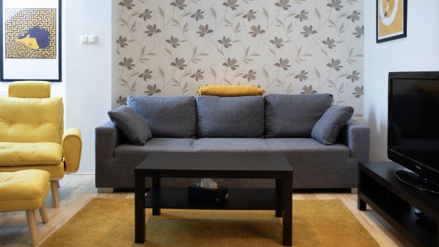 Nappali kanapéval, fotellel, tv-vel egy győri órákra bérelhető lakásban